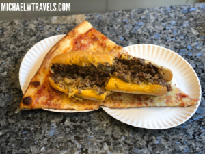a slice of pizza with meat and cheese on a plate