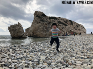 a boy running on a rocky beach