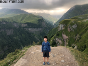 a boy standing on a mountain