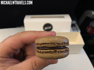 a hand holding a brown macaroon