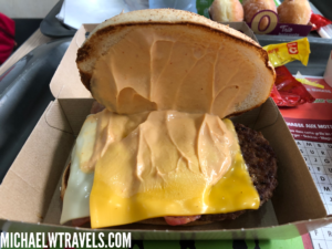 a burger with cheese and sauce in a box