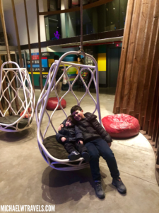 a boy and a boy sitting in a swing