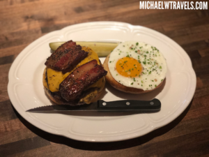 a burger with bacon and egg on a plate