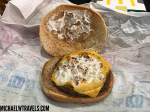 a burger with cheese and sauce on a paper wrapper