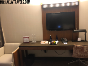 a table with a plate of food and a television on the wall