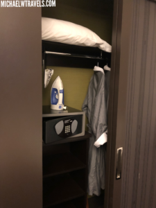 a small closet with a bed and iron