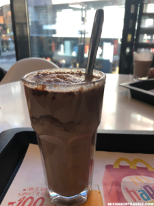 a glass of chocolate milkshake with a spoon
