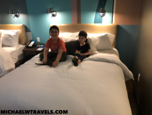 two boys sitting on a bed