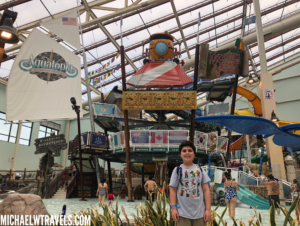 a boy standing in front of a water park