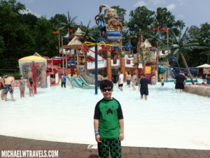a boy standing in front of a water park