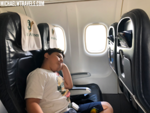 a boy sleeping on an airplane