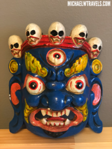 a blue and red mask with skulls on top