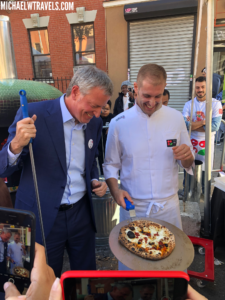 a man in a suit cutting a pizza