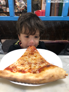 a boy eating a slice of pizza