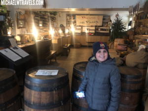 a boy standing in front of barrels