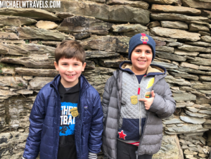 two boys standing in front of a stone wall