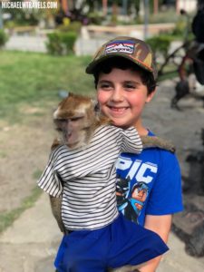 a boy holding a monkey