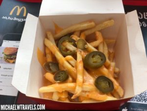 a box of french fries with jalapenos and cheese