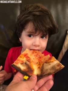 a child eating a slice of pizza