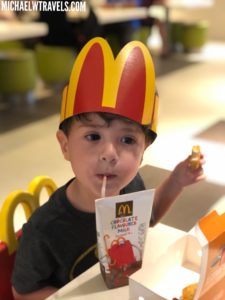 a child wearing a paper crown drinking from a straw