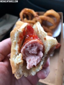 a hot dog with ketchup and onion rings