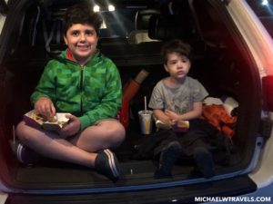 two boys sitting in the back of a car