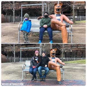 a man and woman sitting on a bench with a person in a mask