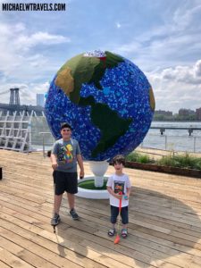 two boys standing in front of a large globe