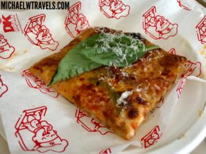 a piece of pizza with cheese and basil on top