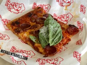 a piece of pizza with basil on top