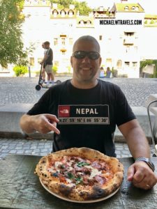 a man sitting at a table with a pizza