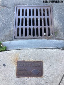 a drain grate on the sidewalk
