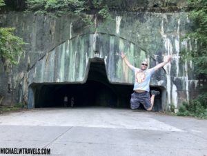 a man jumping in the air in front of a tunnel
