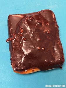 a chocolate covered pastry on a blue surface
