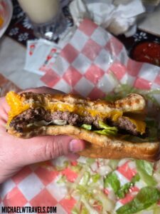 a hand holding a cheeseburger