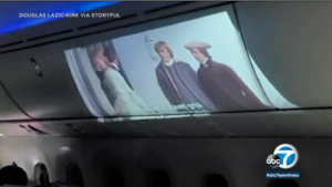 WTF- Airline Passenger Uses Projector To Watch Movie On Overheard Bin During Flight!