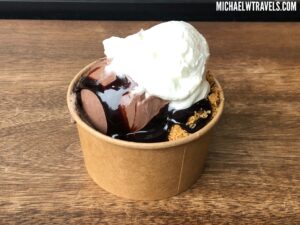 a cup of ice cream with chocolate sauce and whipped cream