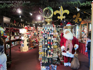 a man in a garment standing next to a display of christmas decorations