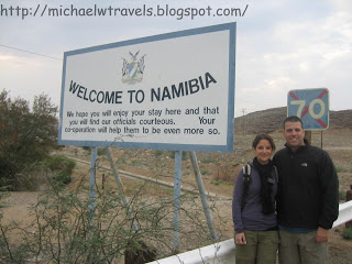a man and woman standing in front of a sign