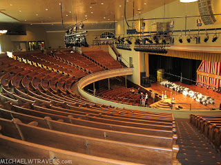 an auditorium with wooden seats with Ryman Auditorium in the background
