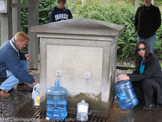 a group of people pouring water into a water fountain