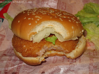 a chicken burger with a bite taken out of it