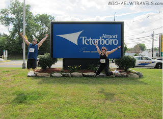 a man and woman jumping in front of a large sign