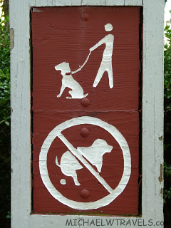 a sign with a person walking a dog