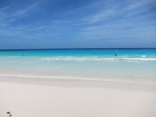 a beach with blue water and blue sky