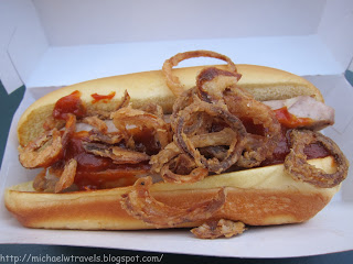 a hot dog with onion rings on top