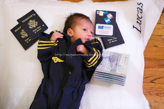 a baby lying on a blanket next to passport and books