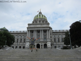 a man jumping in front of Pennsylvania State Capitol