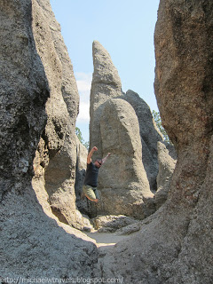 a man jumping in the air between large rocks