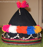 a black hat with multicolored pom poms